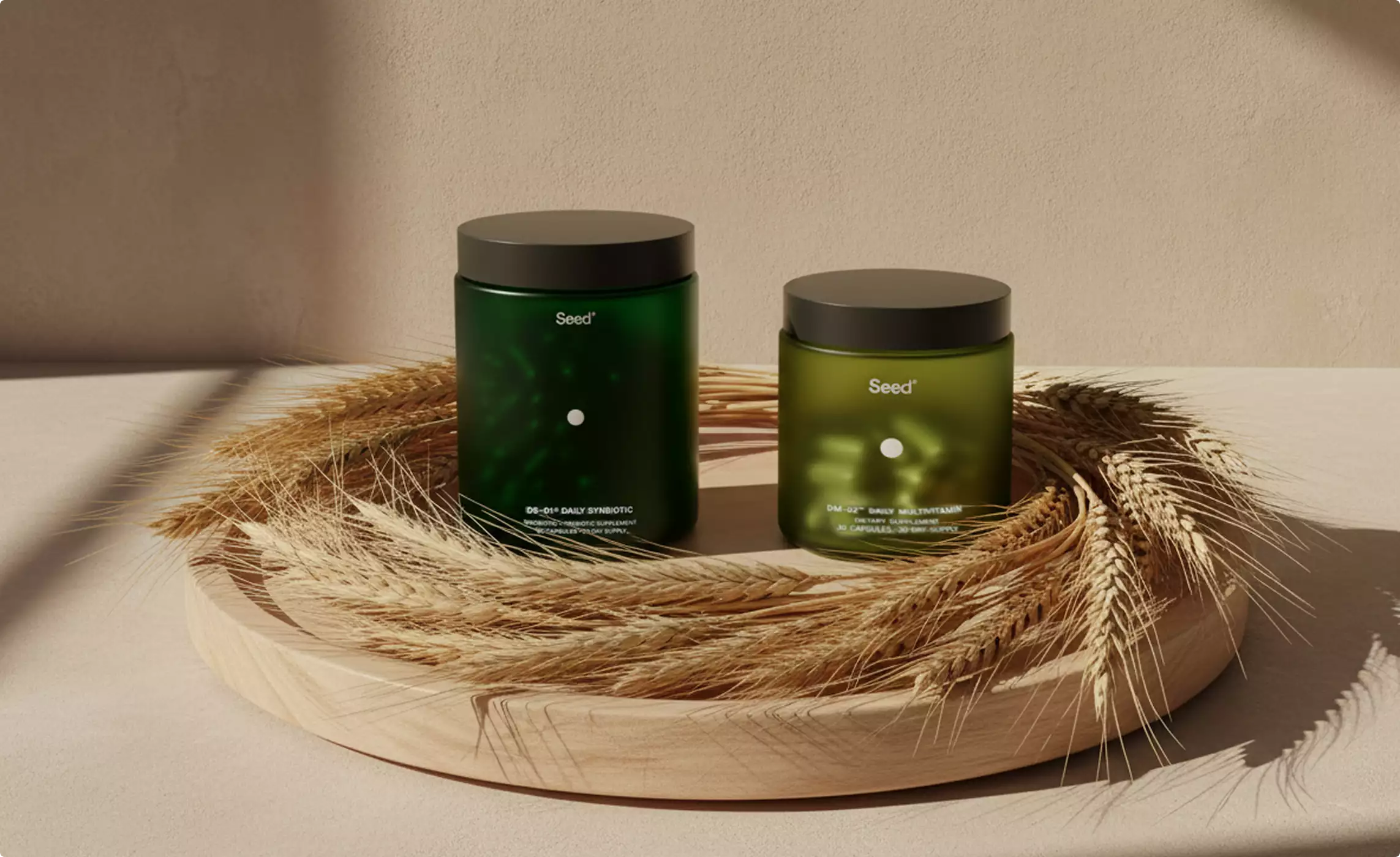 Two green Seed supplement jars on wooden tray with wheat stalks, supplement packaging design