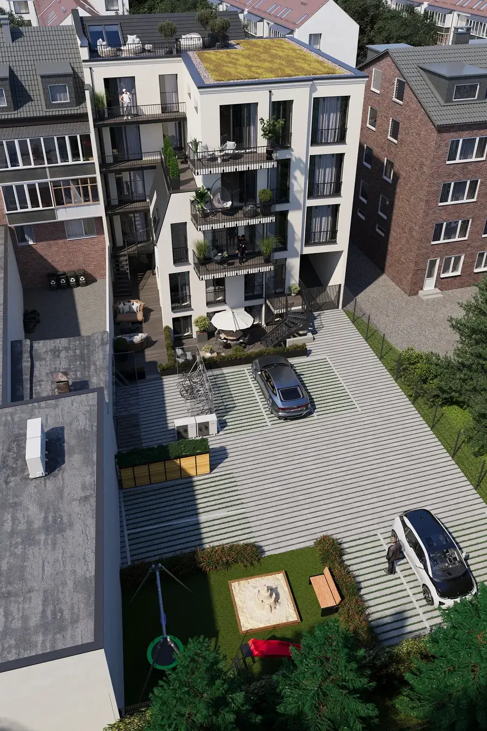 Aerial view of a multi-story apartment building with balconies, inner courtyard, parked cars, and surrounding houses