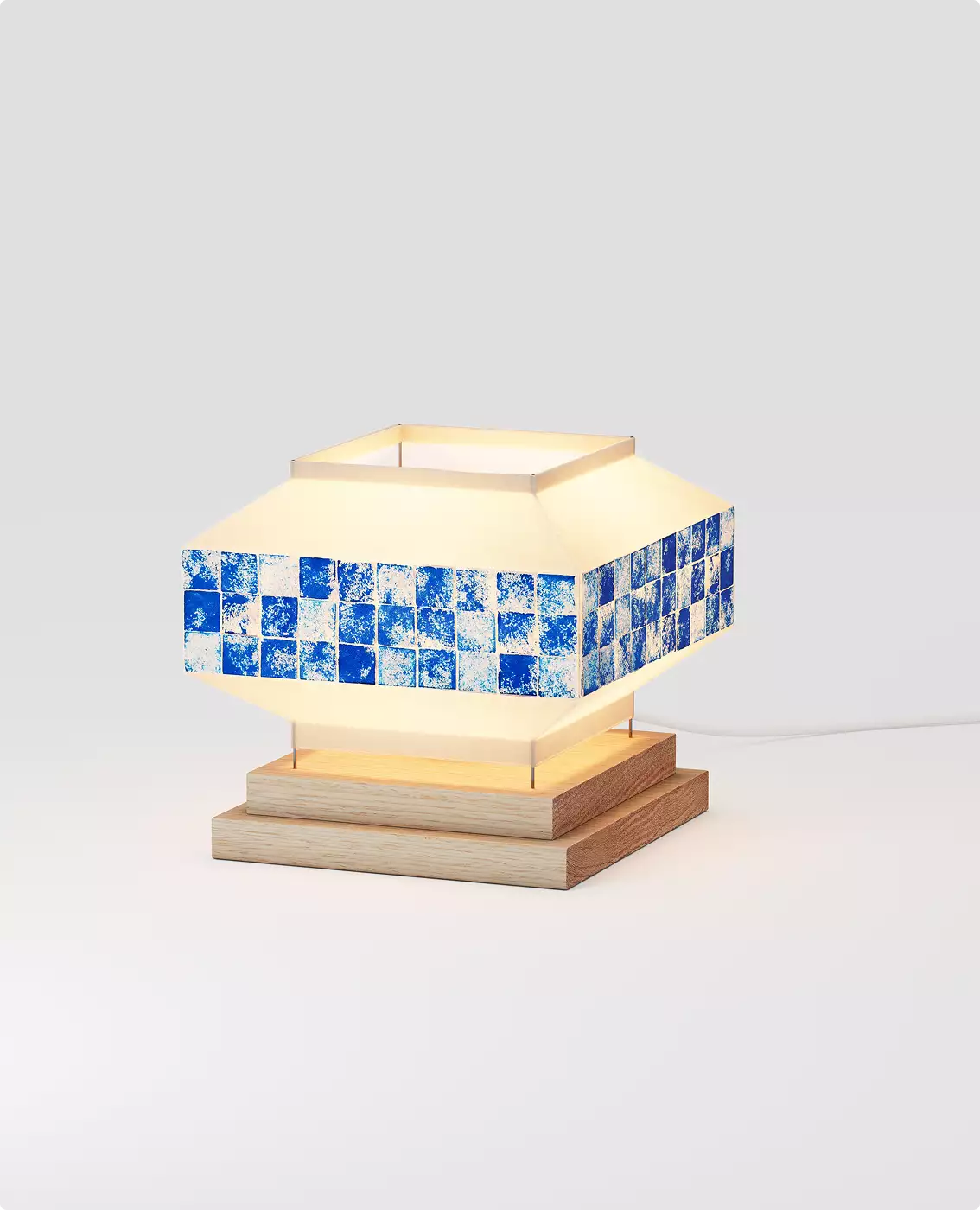 Geometric table lamp with blue tile band and wooden base glowing on neutral background for 3D product visualization