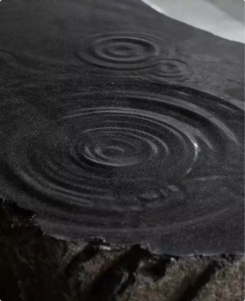 Apartment render black stone surface with water ripple rings and wet texture detail