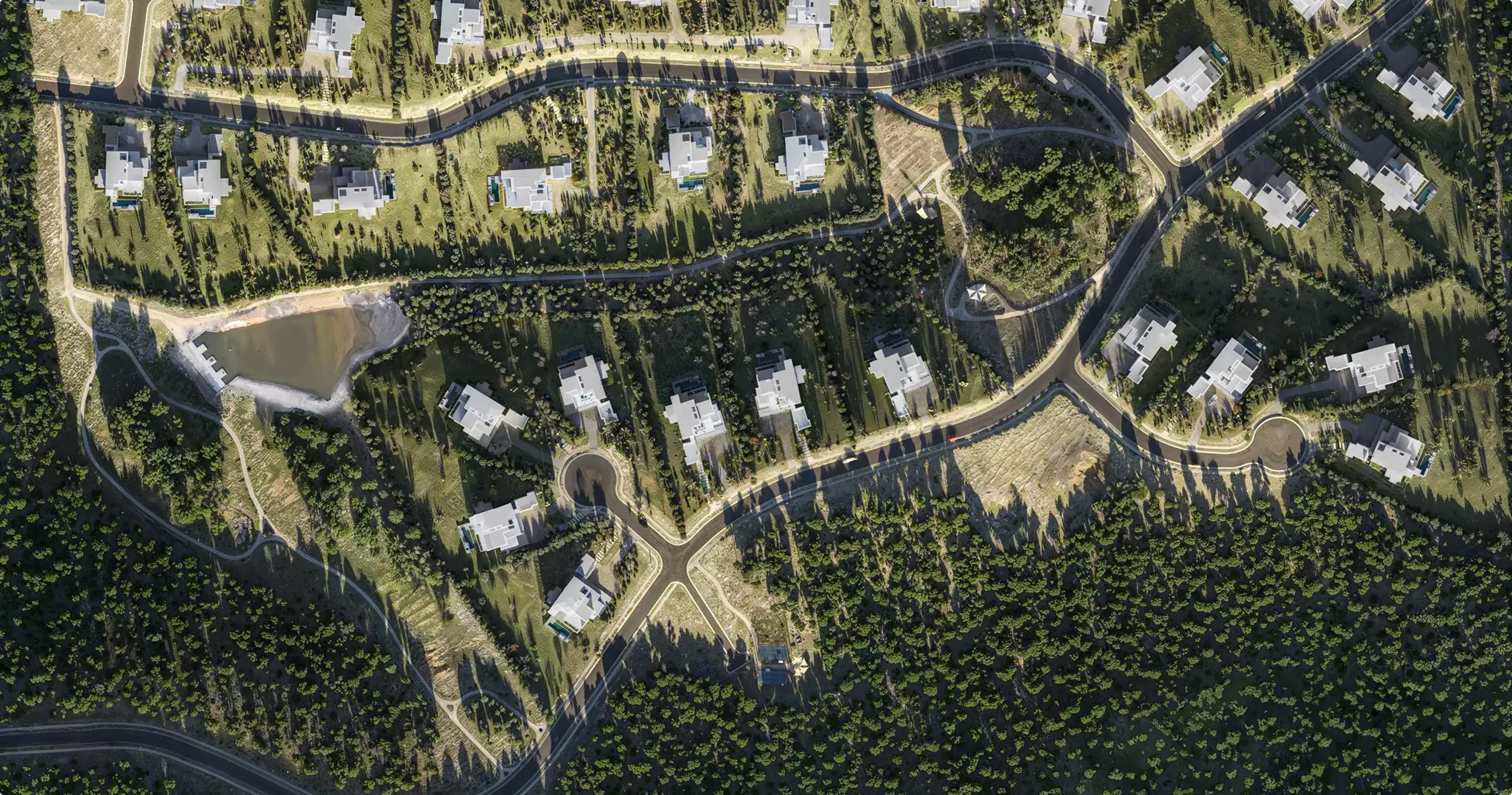 Birds eye architectural renderings of a villa site plan with curving roads, trees, and modern homes