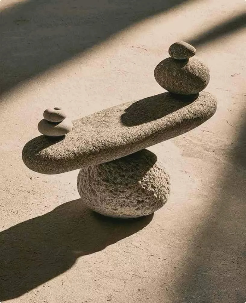 Cgi hotel with stacked balancing stones on a textured surface in warm directional light