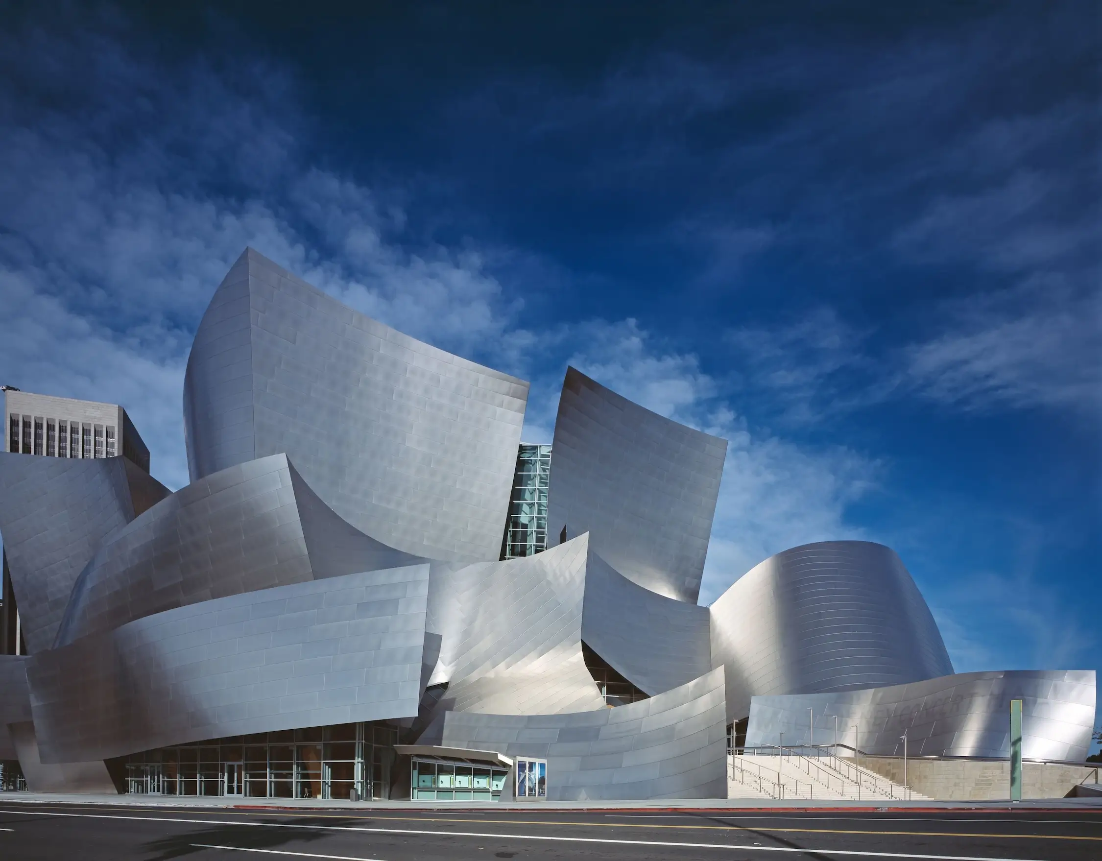 Contemporary architecture silver sculptural building under a blue sky, with curved metal forms