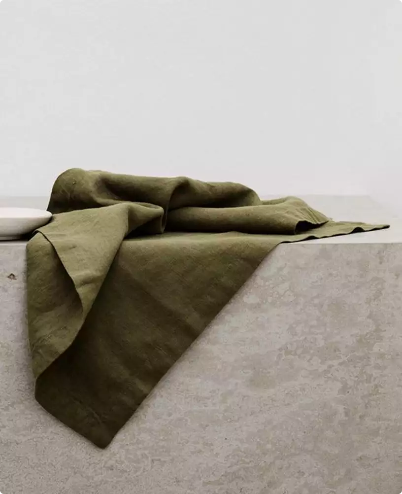 Olive fabric draped on a stone plinth, furniture 3D rendering with soft folds and a neutral backdrop