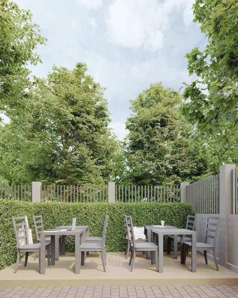 Green architecture patio with gray tables among hedges and trees, sustainable design outdoor courtyard