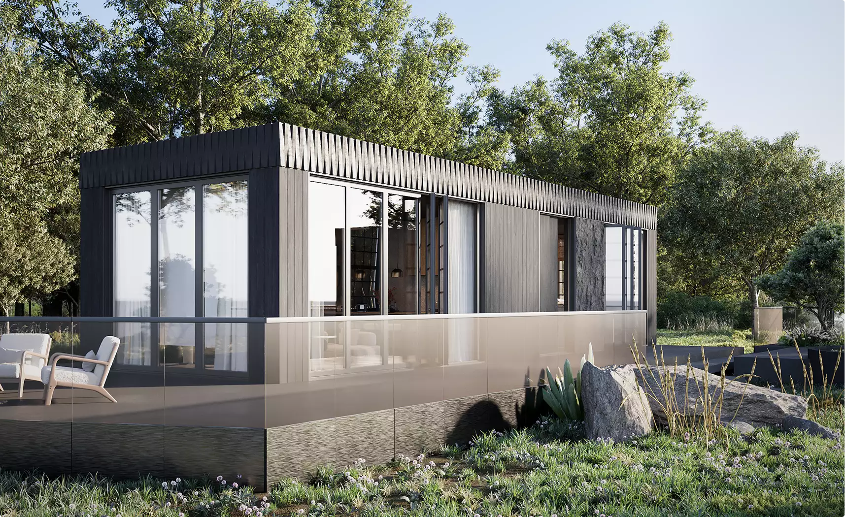 Modular home exterior with dark cladding, tall glass walls, and terrace railing in a wooded setting