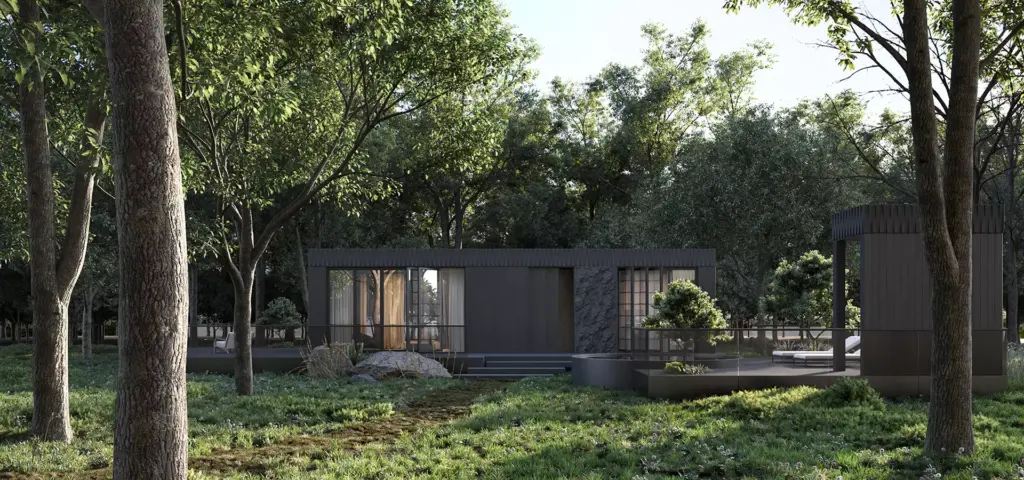 Modular home exterior in a forest clearing with broad deck, glass facade, and landscaped path