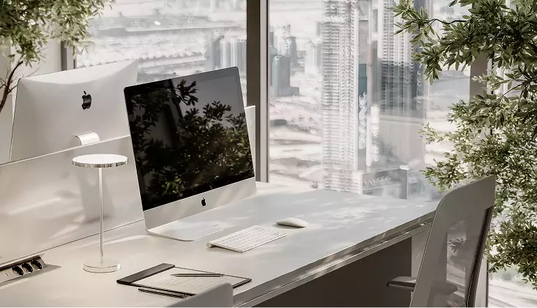 Office building rendering of a bright workstation with desktop monitor beside floor-to-ceiling windows