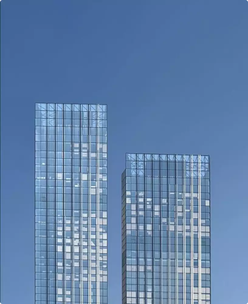 Office interior renderings of modern glass office towers rising against clear blue sky