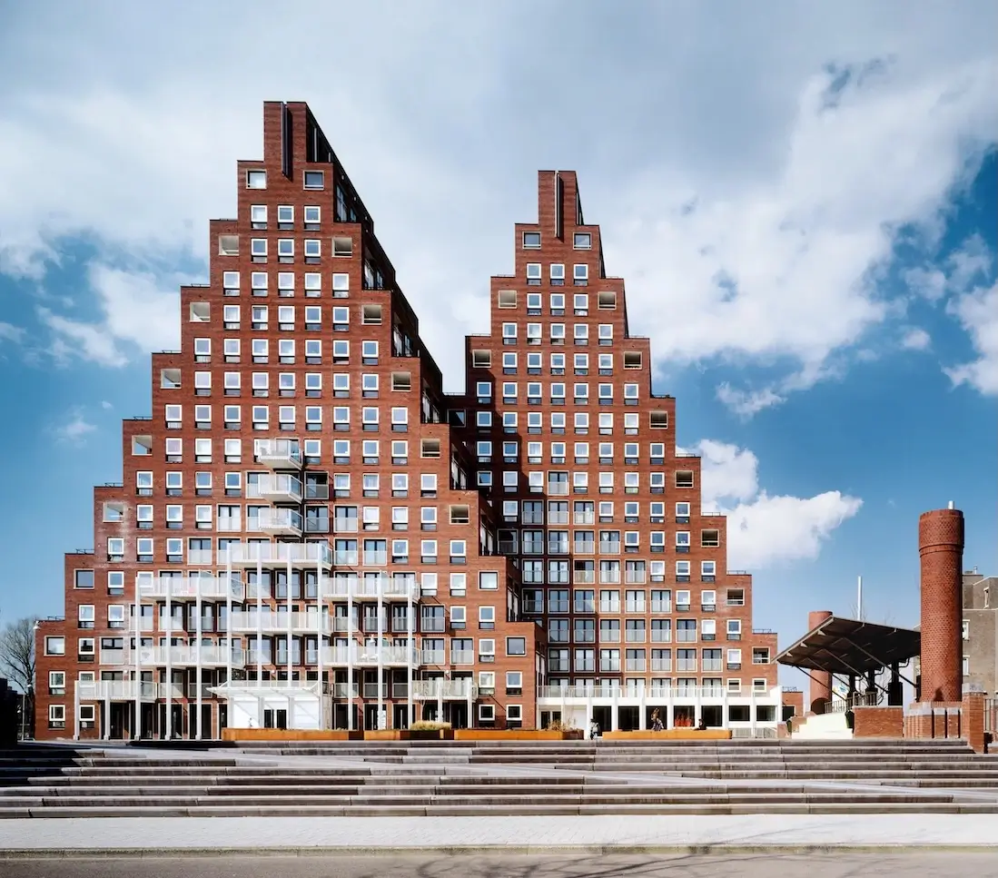 Postmodern architectural style stepped brick building with geometric facade and modern urban plaza