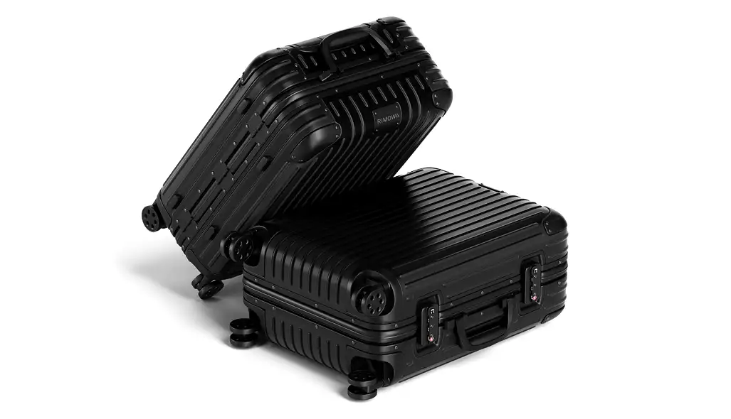 Product design rendering of two black suitcases stacked on a light background