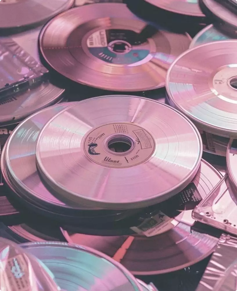 Product rendering services for stacked compact discs with pink reflections in a close-up arrangement