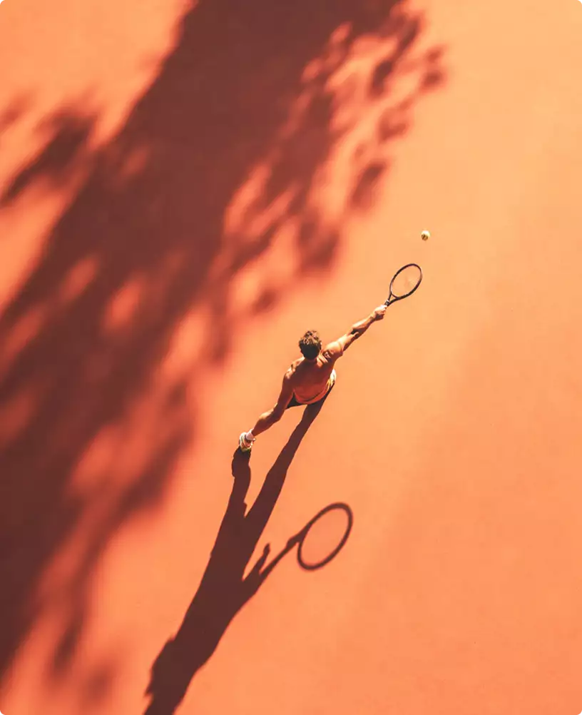 Clay tennis court design top view with player silhouette hitting ball and shadow under trees