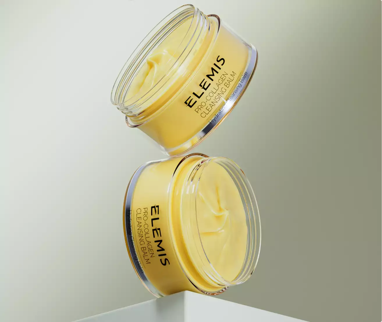 3d cosmetic two cleansing balm jars stacked at angle with visible creamy texture on light background