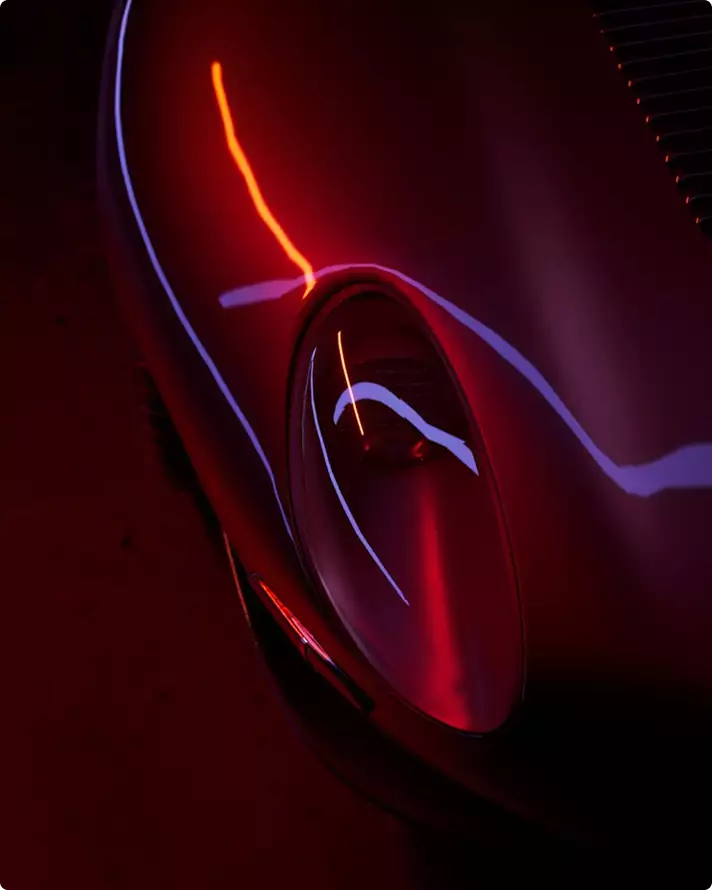 Automotive marketing rendering service close-up of a dark sports car headlight under red lighting
