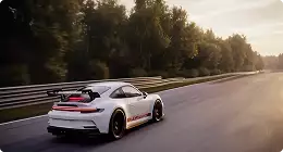 Automotive studio rendering service white race coupe driving on a track, rear three-quarter view