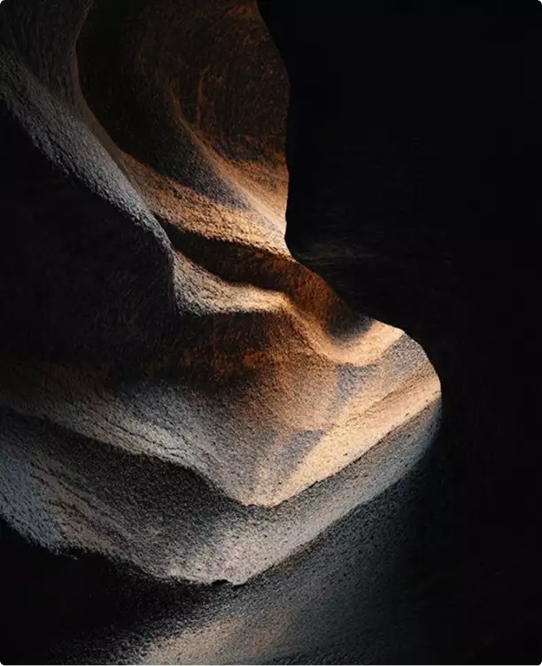 Abstract rock formation with light and shadow creating curves, black apartment design