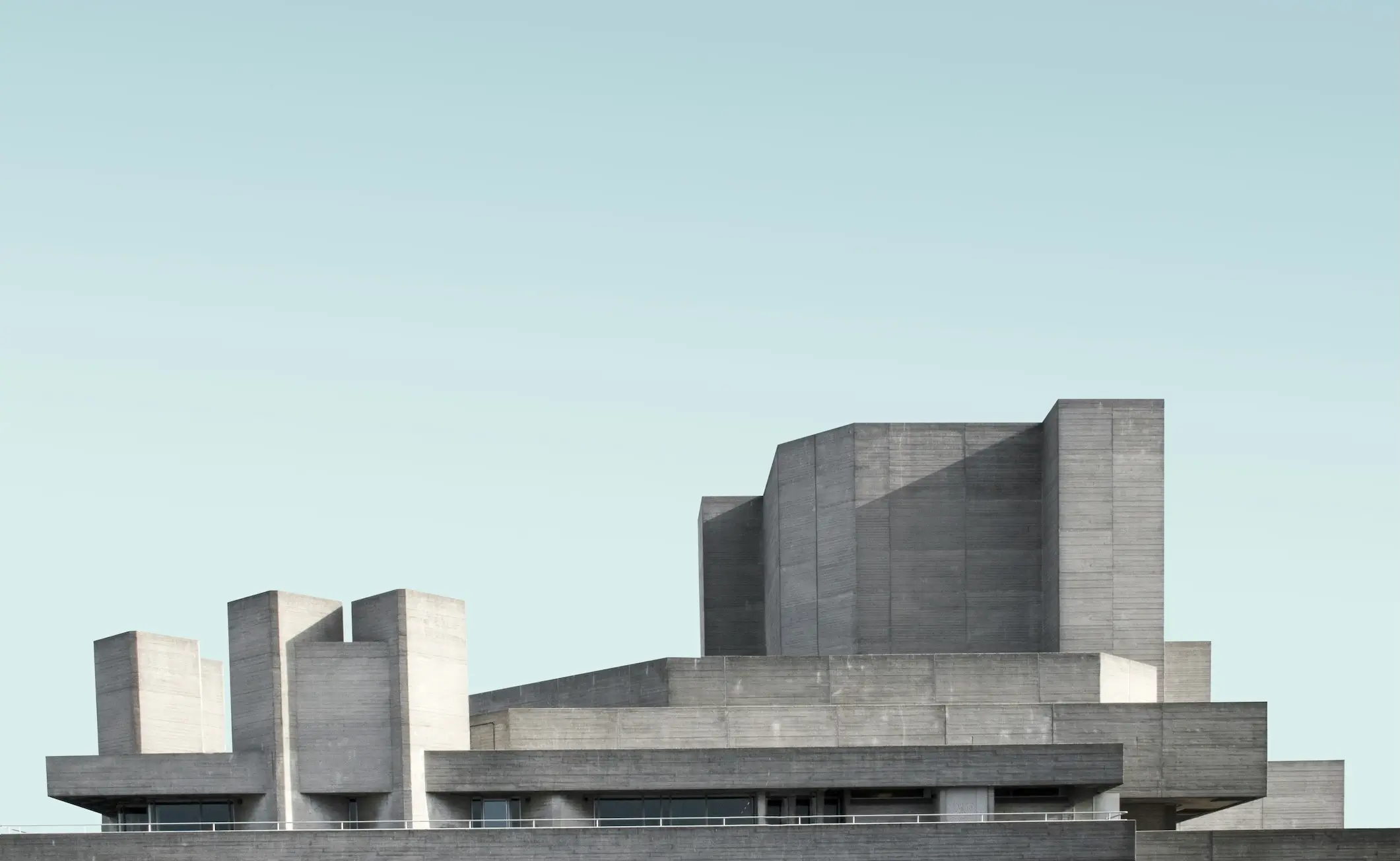 brutalist building with massive geometric volumes and minimal ornament