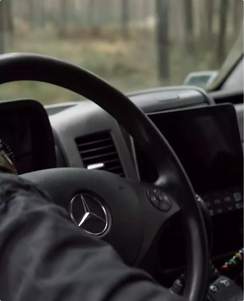 Forestry vehicle product rendering driver view with steering wheel dashboard and forest outside