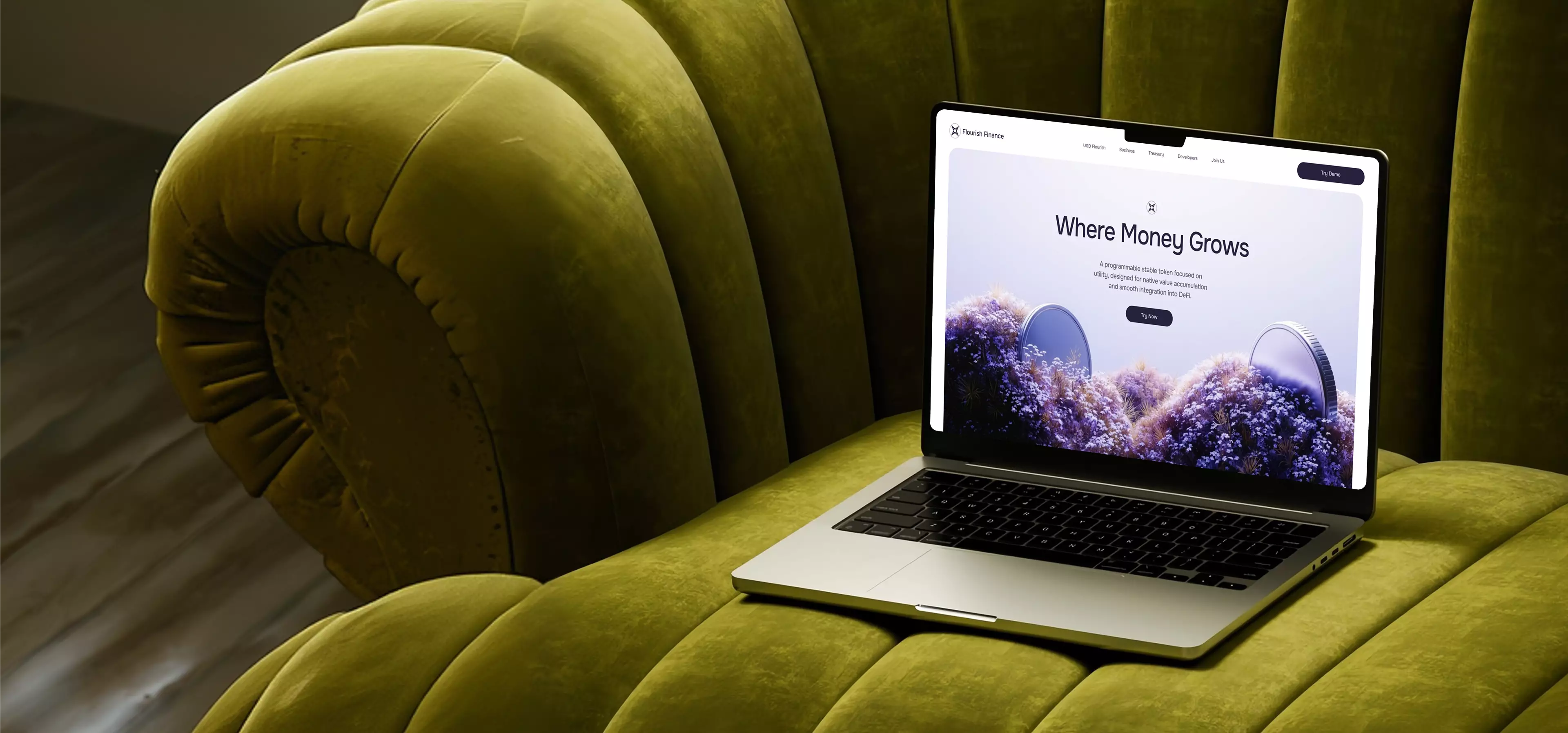 Laptop on a green velvet sofa showing a landing page design for a finance website