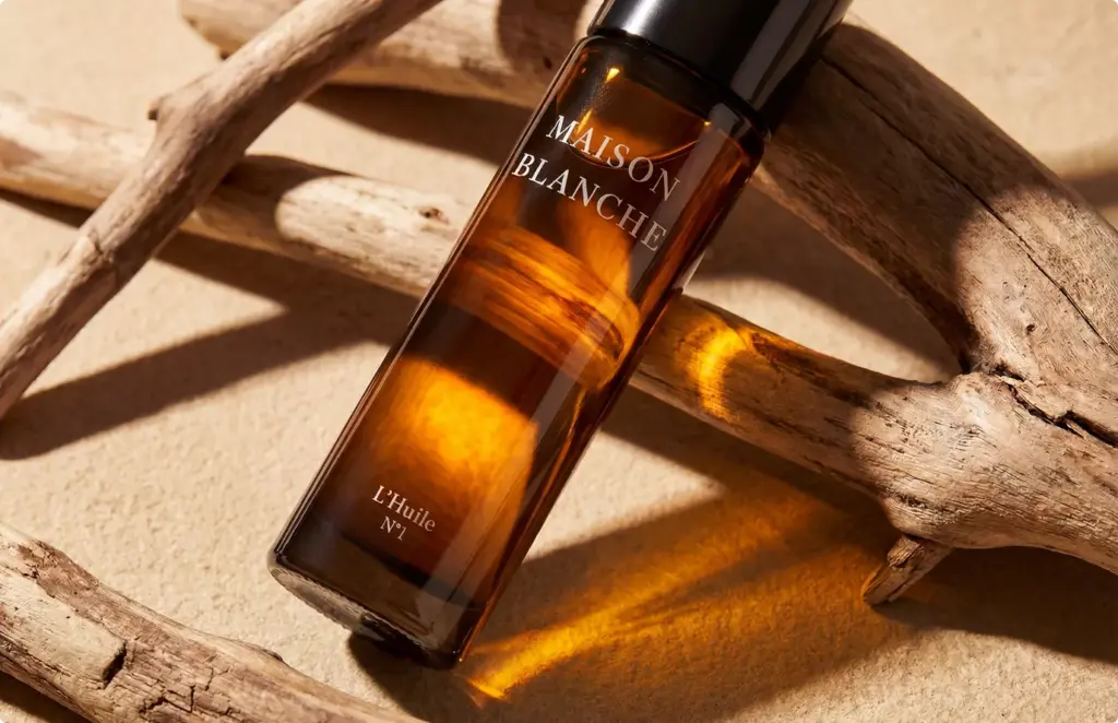 Amber glass bottle on driftwood with sunlight, product rendering with warm reflections