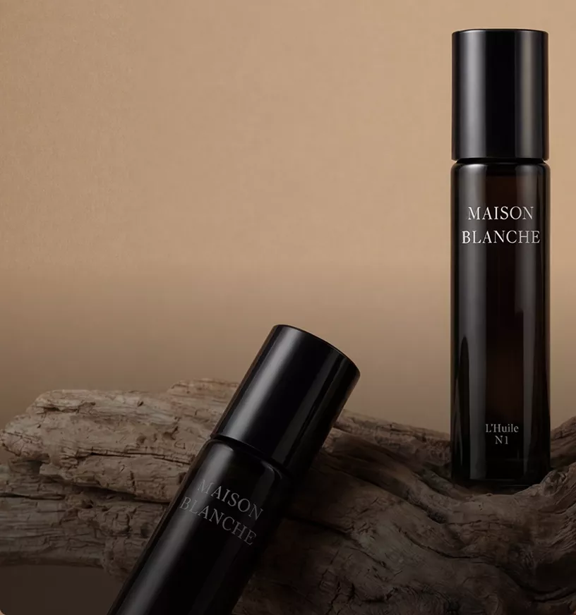 Two amber bottles on driftwood in beige studio, product rendering with soft lighting