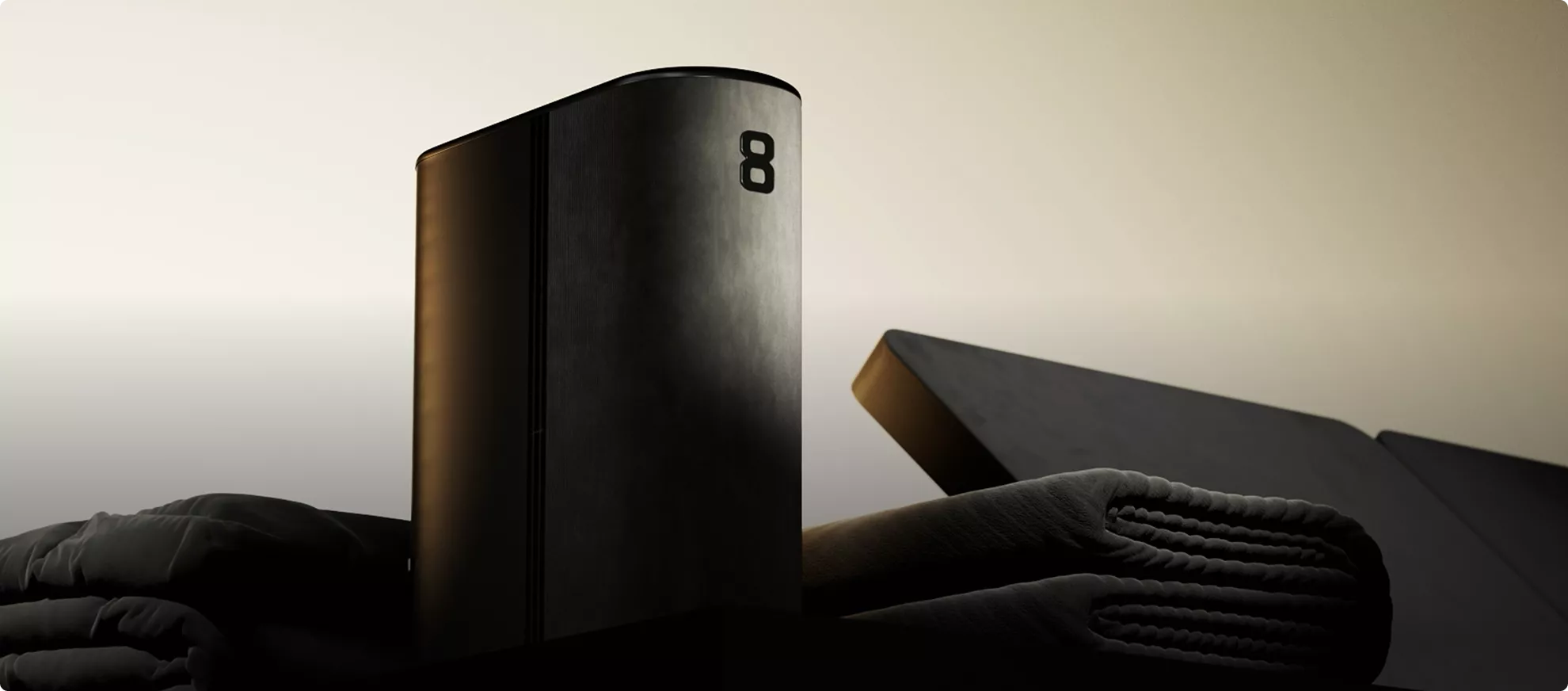 Matte black device with folded textiles in studio, product rendering with soft shadows