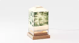 Decorative lamp with illustrated panels on wooden base, product rendering in minimal studio