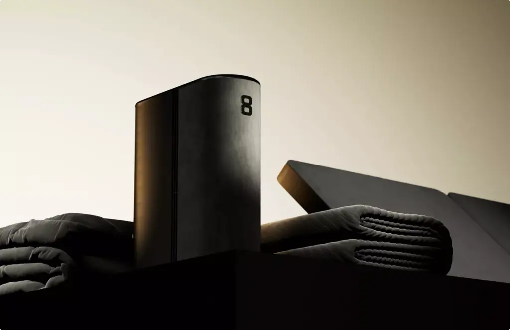 Minimal black device with soft fabric accessories, product rendering moody lighting