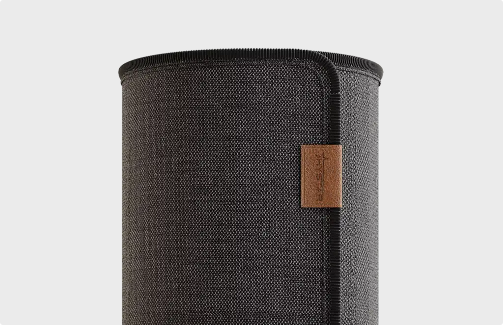 Fabric speaker with textured grille and leather tag, product rendering close-up detail