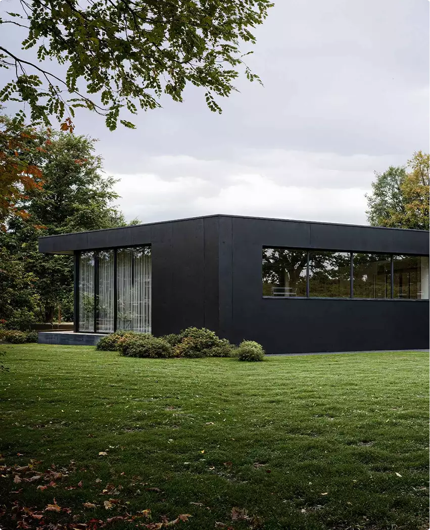 Side view of single family home rendering with black exterior, long windows and lawn