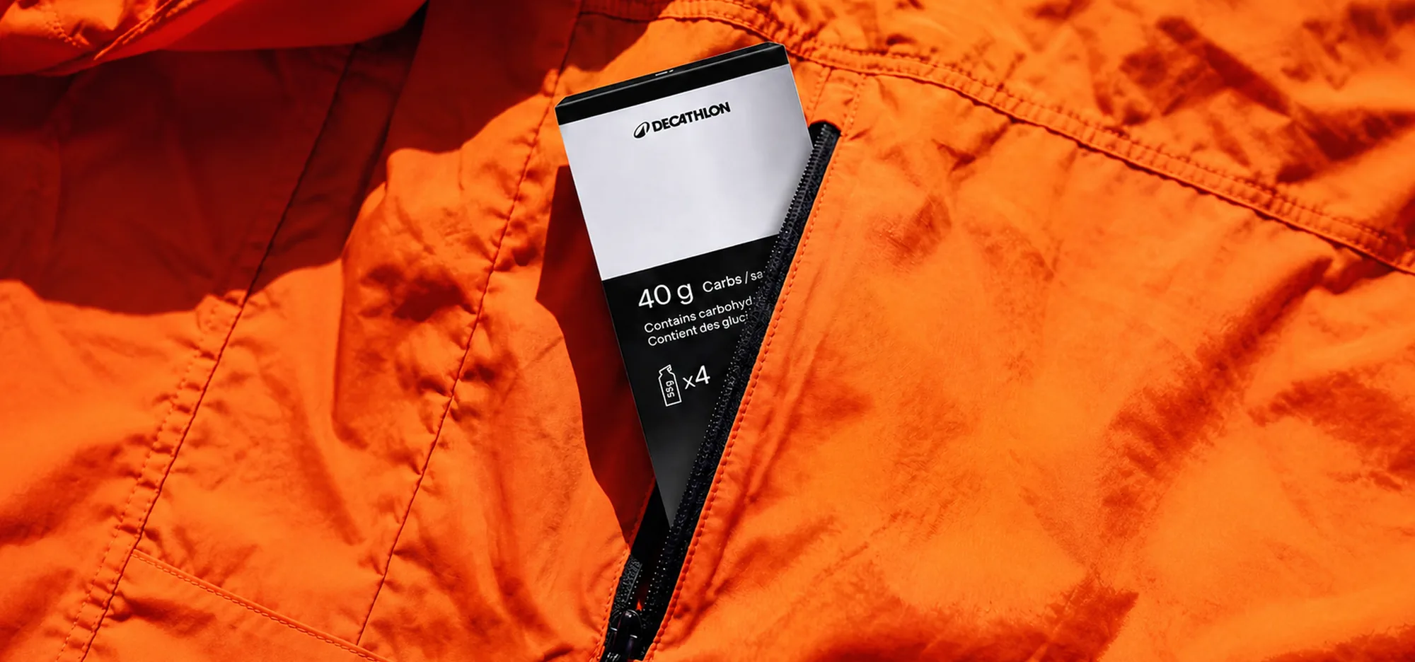 Decathlon energy gel sachet in an orange jacket pocket.