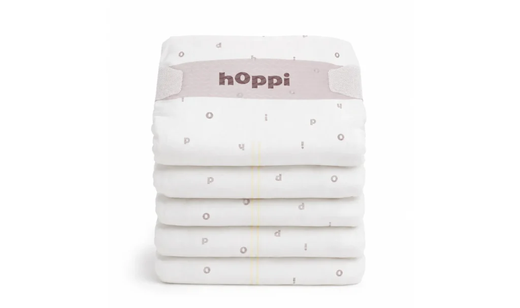 Neat stack of folded hoppi diapers with logo waistband, baby diaper product visualization.
